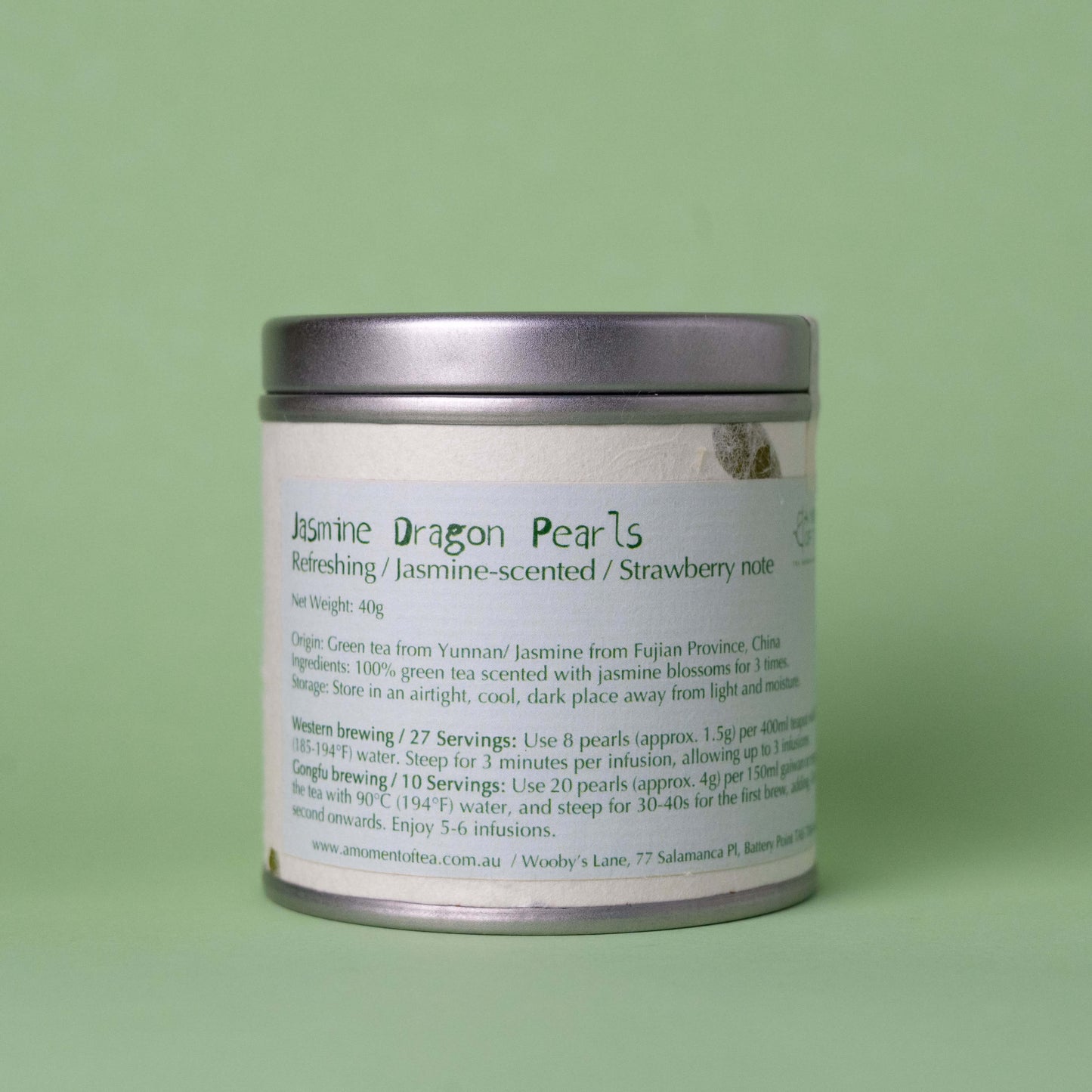 Tea tin labeled 'Jasmine Dragon Pearls' on a green background