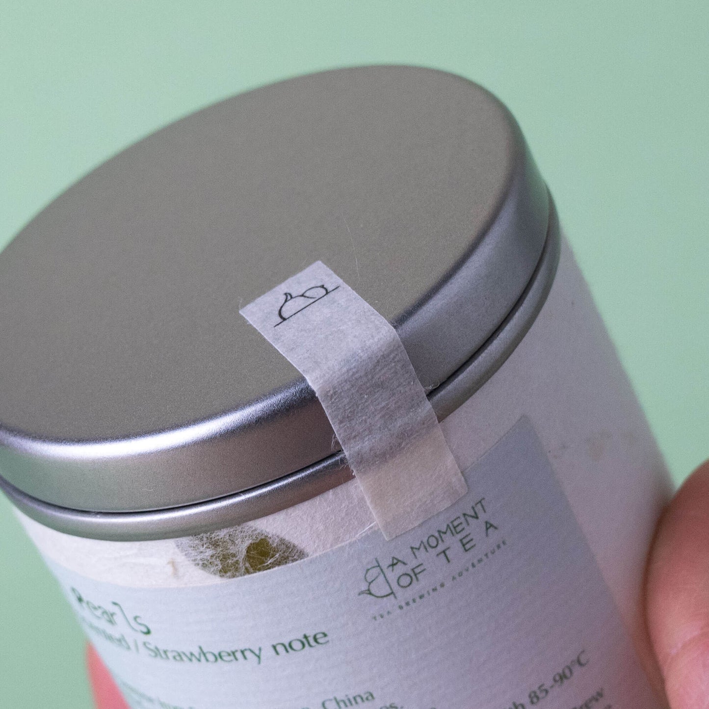 Close-up of a tea canister with a label on a green background.