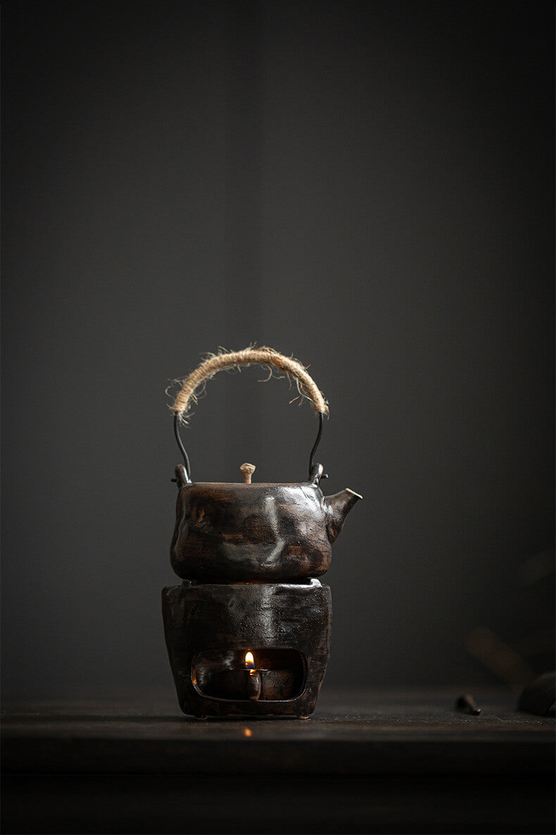 Traditional ceramic teapot with a candle inside on a dark background
