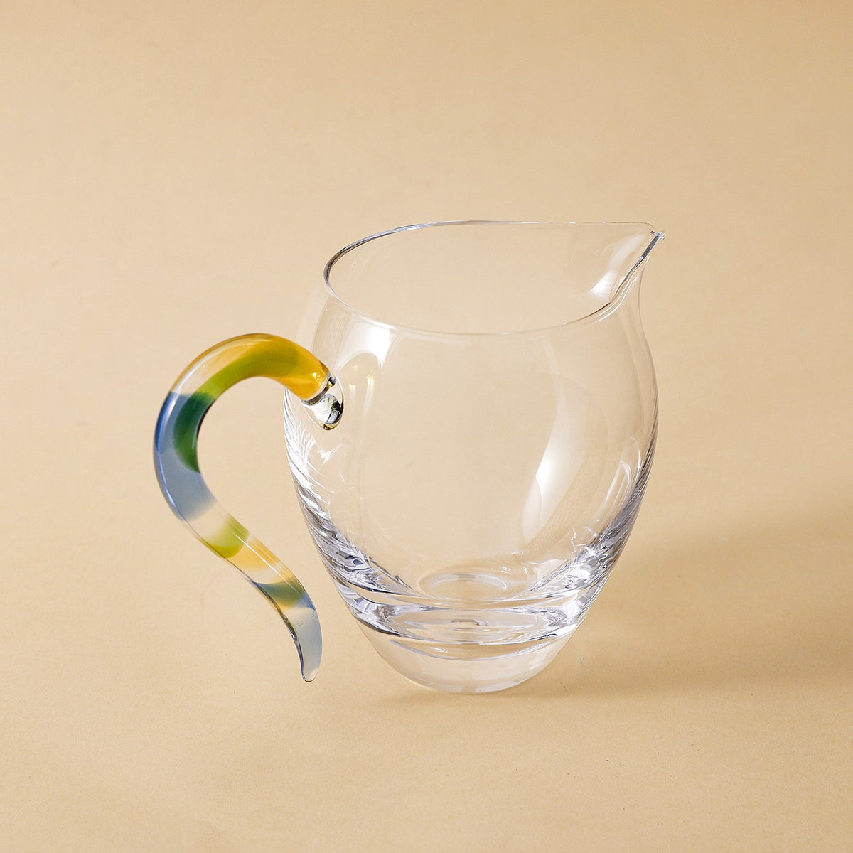 Thick-base glass gongdao cup with swirled Rainbow handle, three-quarter view on beige