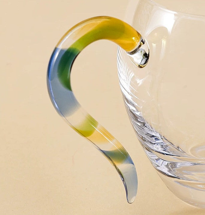 Close-up of the twisted yellow, blue and green glass handle where it joins the cup