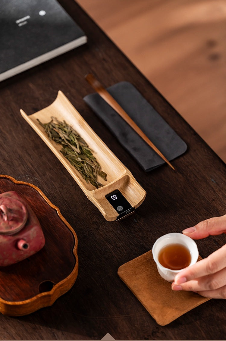 Bamboo tea scale on a tea table with a tea needle, cloth, teapot and cup