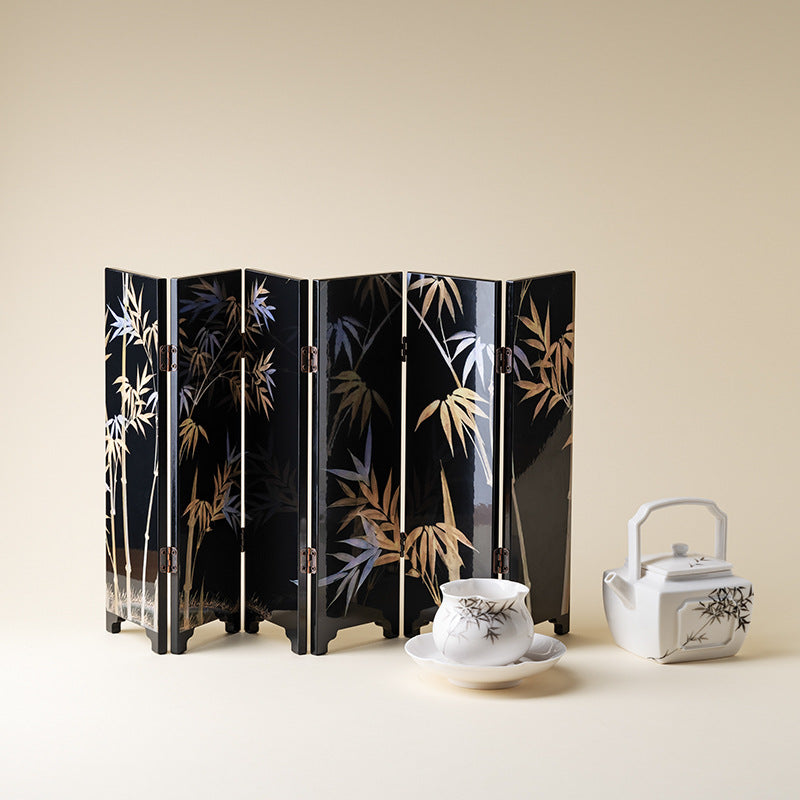 Black Bamboo mini folding screen, front bamboo side, standing behind a white square teapot and a cup on a saucer