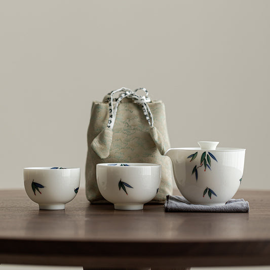 Set of ceramic Gaiwan set with bamboo design on a wooden table with a beige background