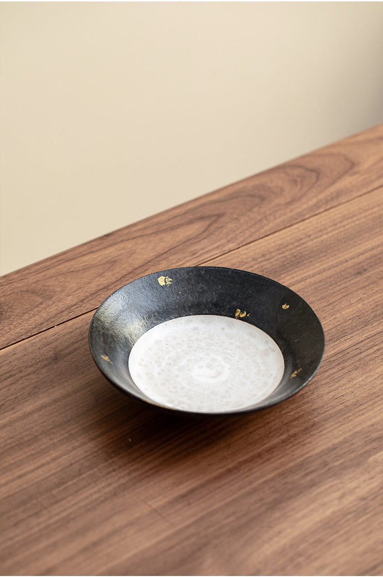 Black stoneware teapot stand on a timber table