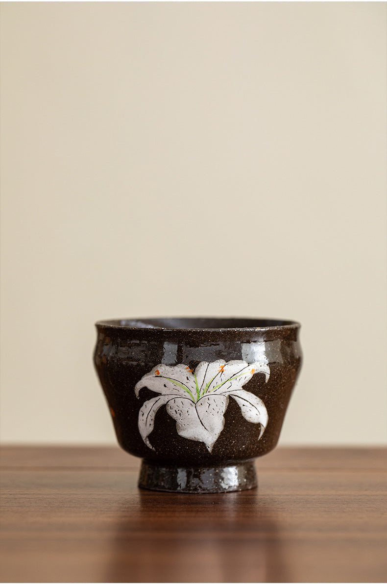 White lily stoneware tea cup on a timber table