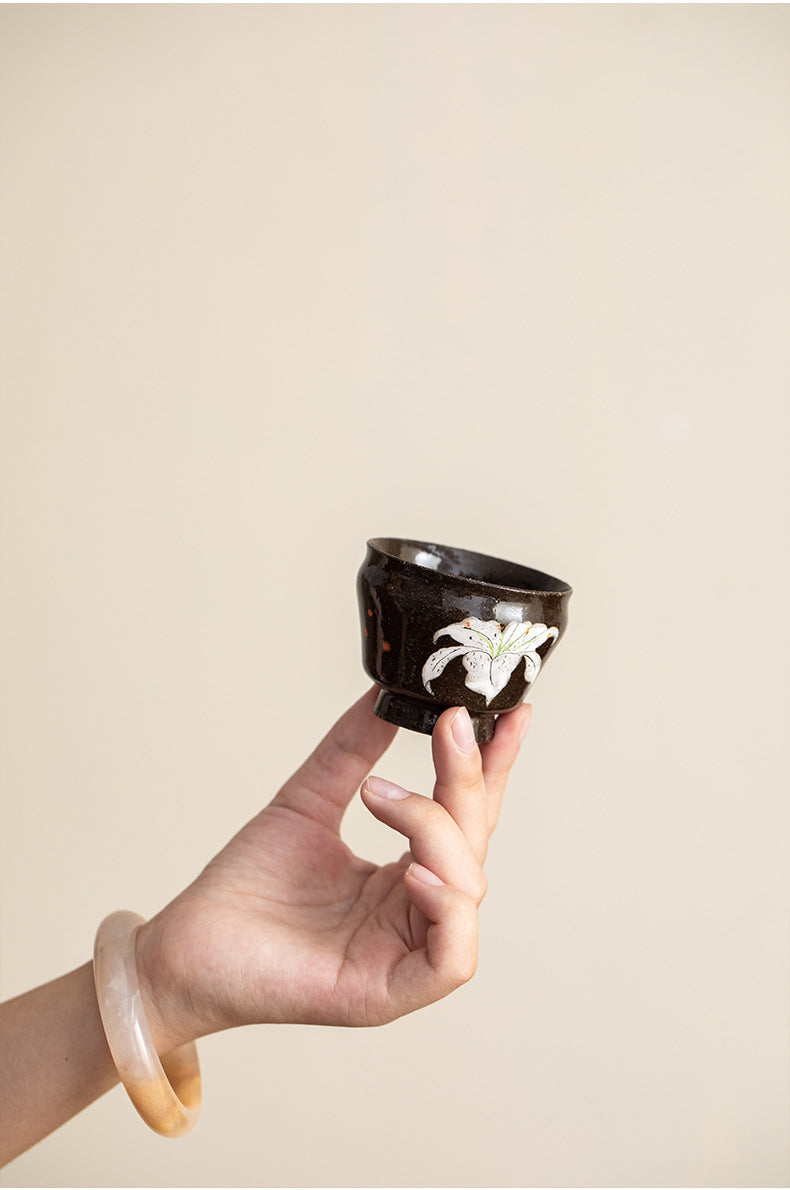 White lily tea cup held in hand to show its size