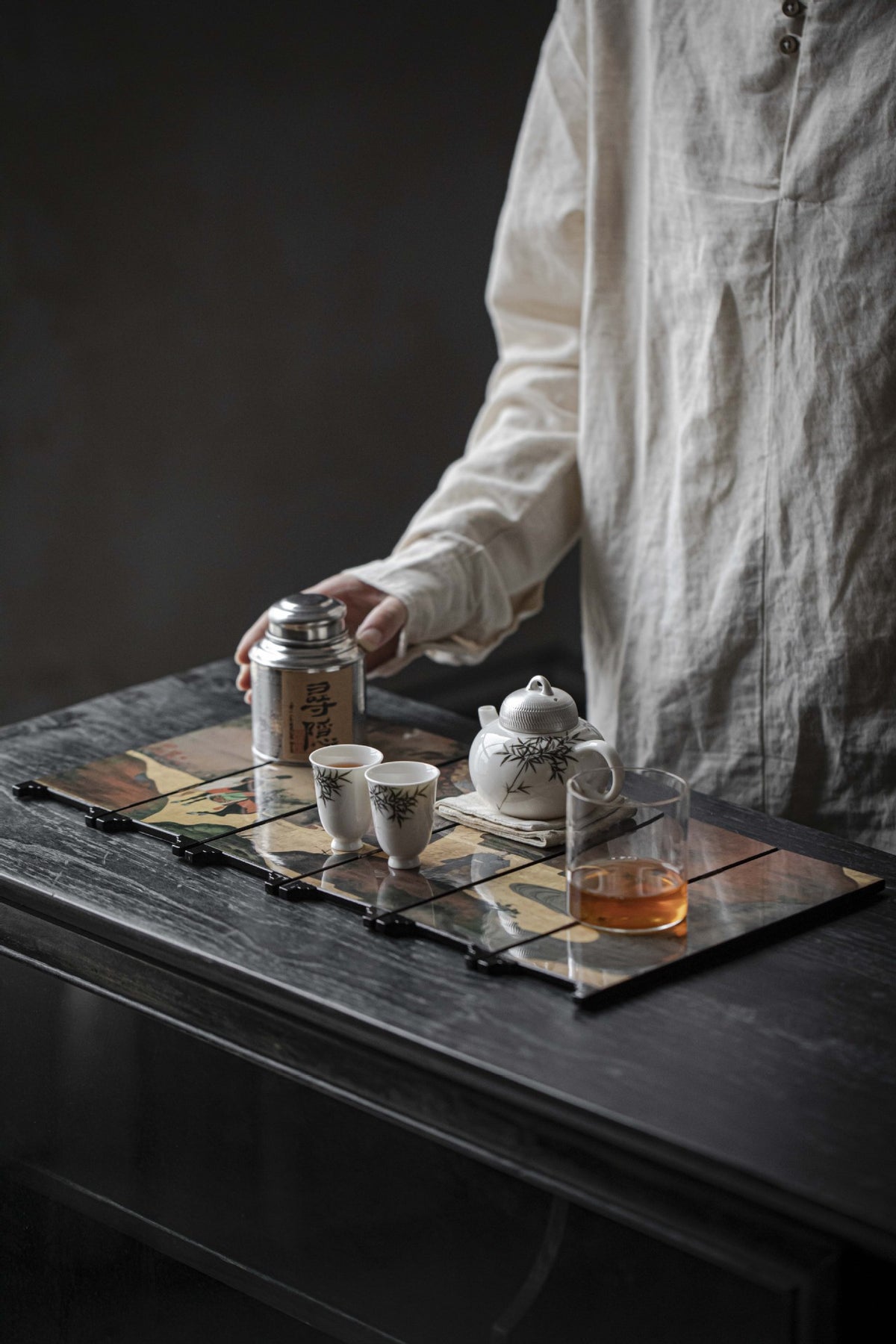 Gold Meadow mini folding screen opened flat on a tea table as a mat, with tea canister, cups and teapot on it