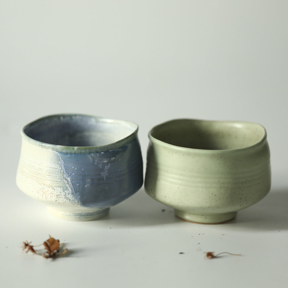 Blue and green ceramic matcha bowls on a light grey background