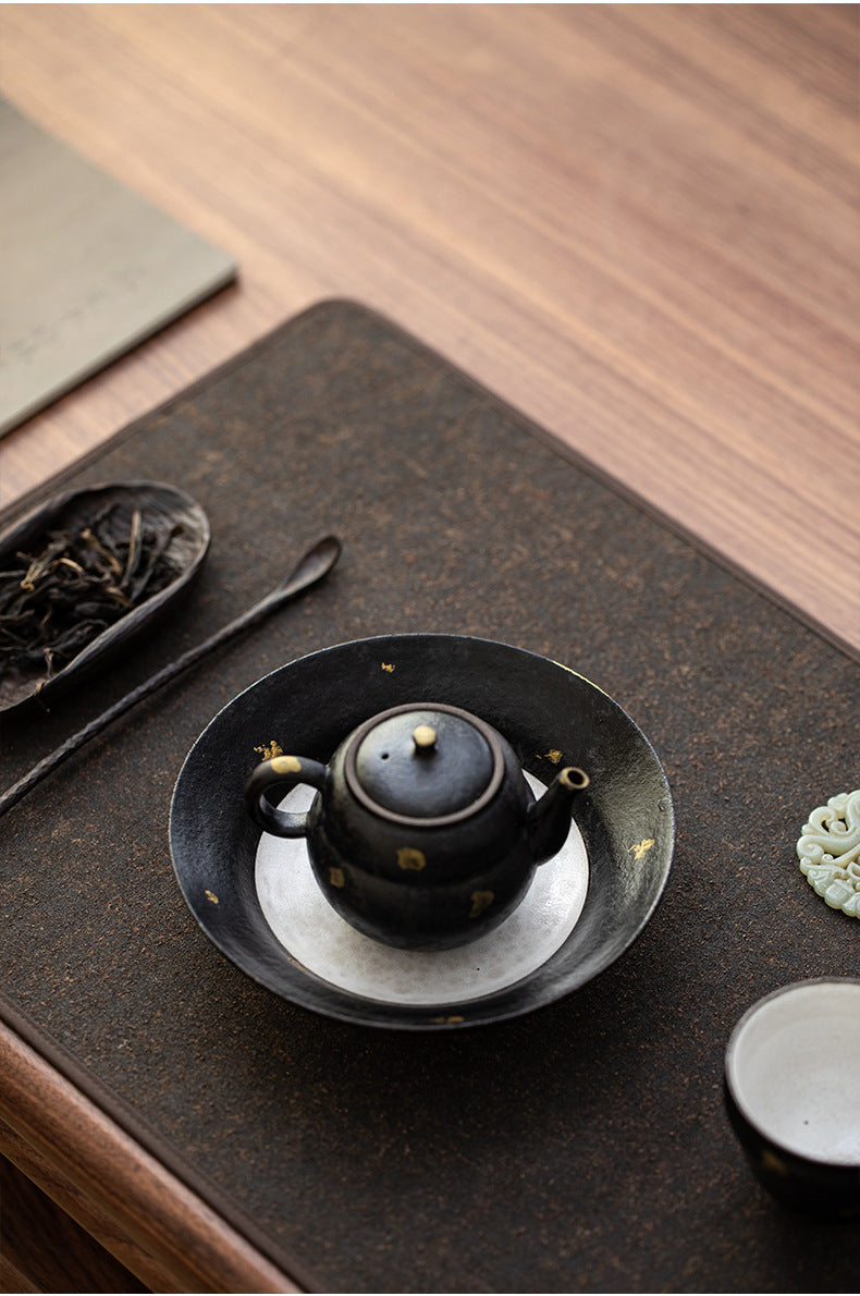Black clay gourd teapot sitting on the gold fleck teapot stand