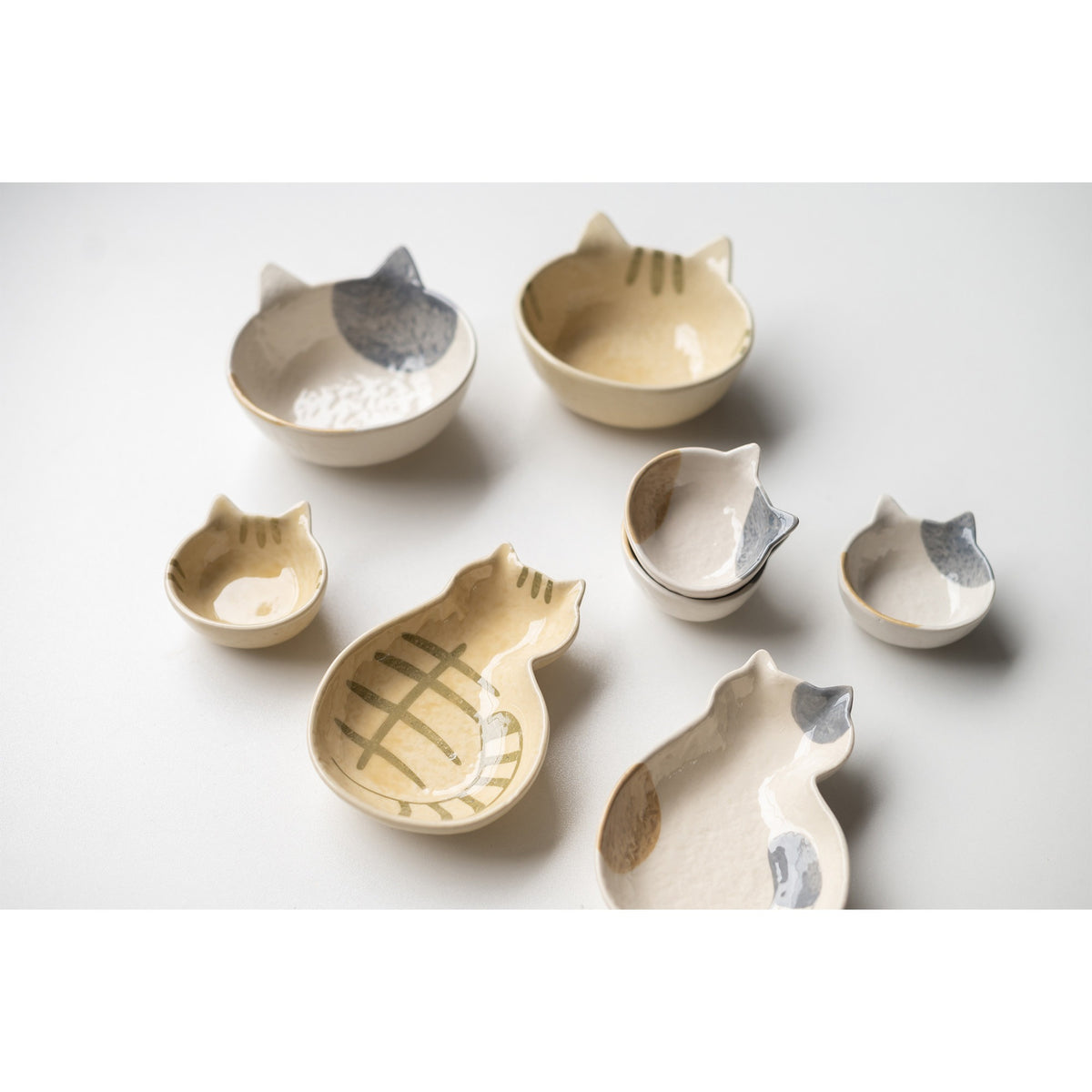 Cream cat ceramic dishes, bowls, plates and mini dishes grouped together