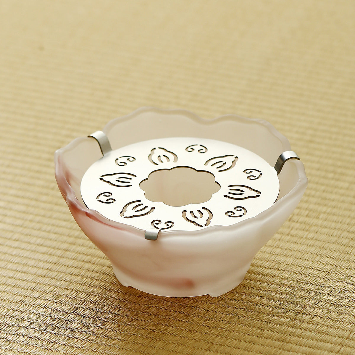 Pink frosted glass tea warmer with steel tealight plate on a tatami mat