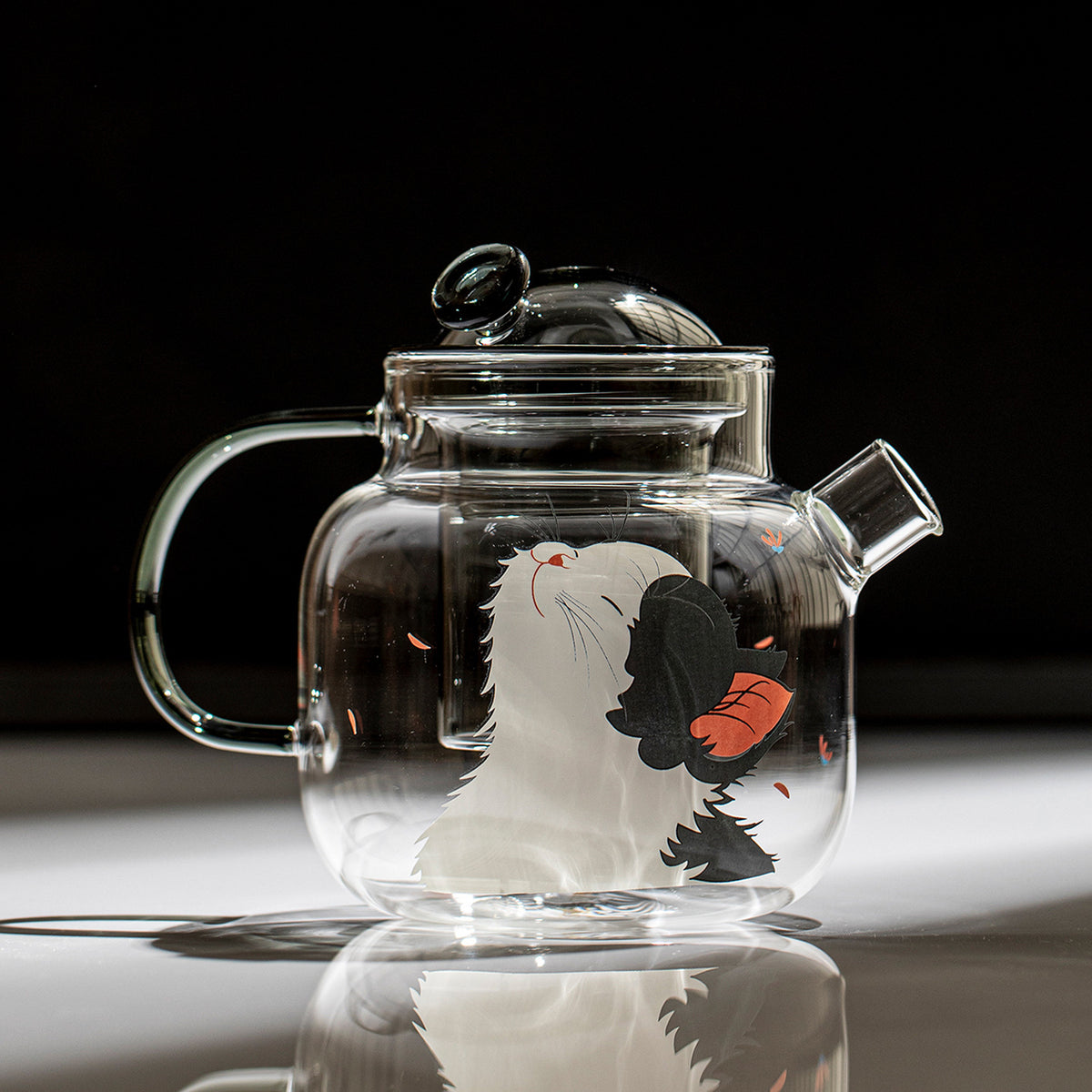 700ml clear glass teapot with smoke-grey lid, infuser and handle, printed with a black and white cat and an orange butterfly