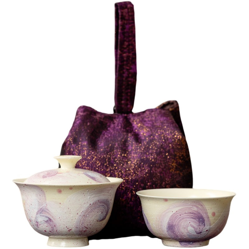 Purple swirl travel gaiwan set: gaiwan, cup and brocade pouch on a white background