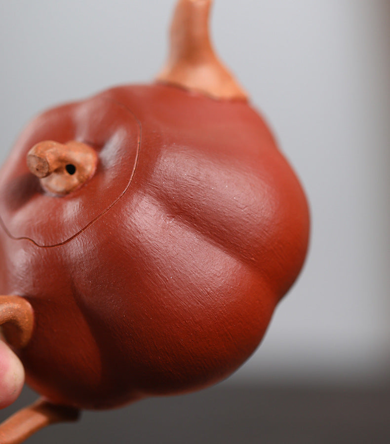 Close-up of The Pumpkin Yixing clay teapot, showing the ribbed segments of the body and the stem knob on the lid
