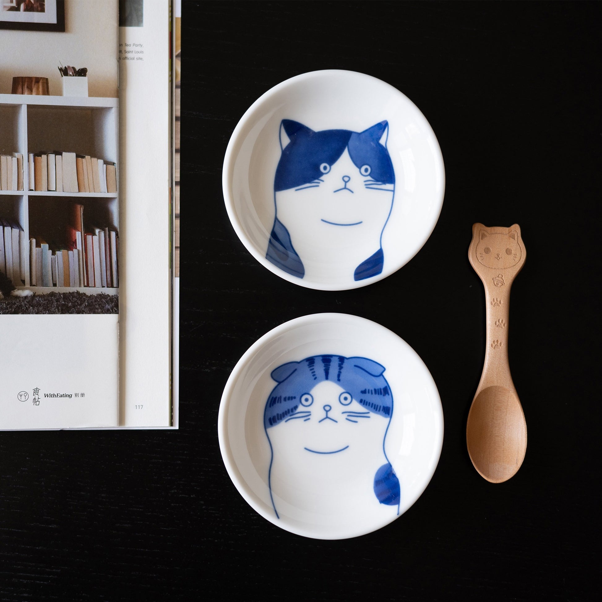 Two blue cat face sauce dishes beside a cat-shaped wooden spoon