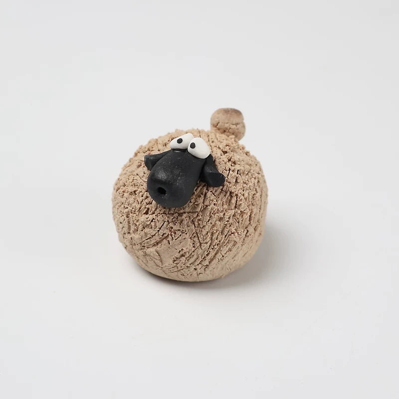 Sandy khaki hand-pinched pottery sheep tea pet with a black face and googly eyes
